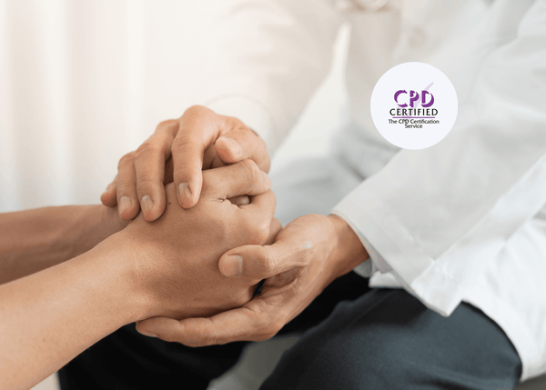 Close-up of a healthcare professional in a white coat offering a reassuring touch by gently holding someone’s hands.