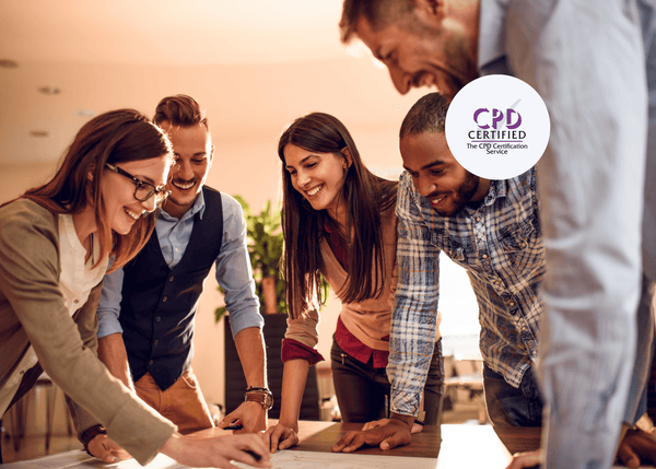 Five colleagues gathered around a desk, smiling and collaborating on a shared project in a bright, modern workspace.