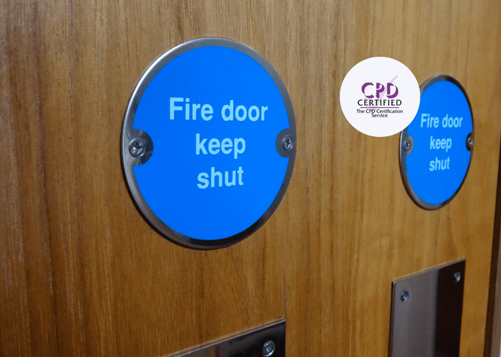 Fire door with blue signs and 'CPD Certified' logo on a wooden background