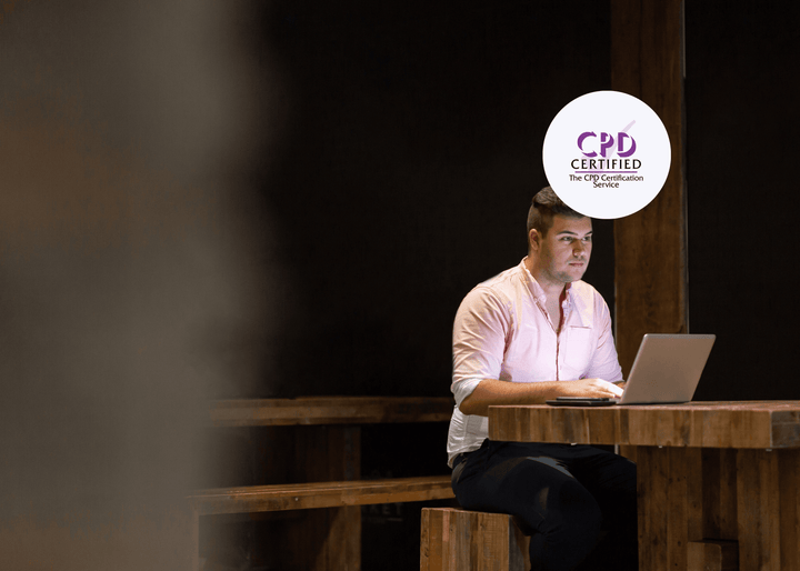 A man sits alone at his desk in a dark room, the only light coming from his laptop screen, illustrating the isolation of a lone worker.