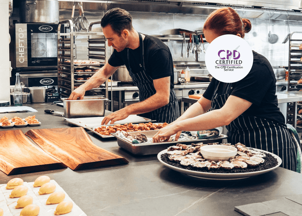 Chefs working in a professional kitchen, preparing food as part of CPD-certified Level 1 Food Safety training in a catering environment.