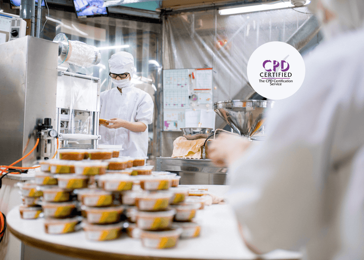 Food factory staff wearing protective clothing handle packaged meals on a production line, demonstrating hygiene and safety practices in food manufacturing.