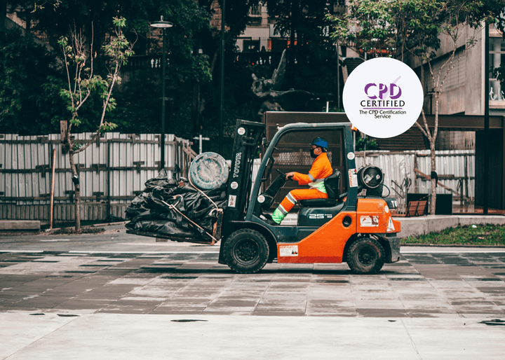 Construction worker in orange PPE operating a forklift, transporting waste materials across an outdoor urban worksite.