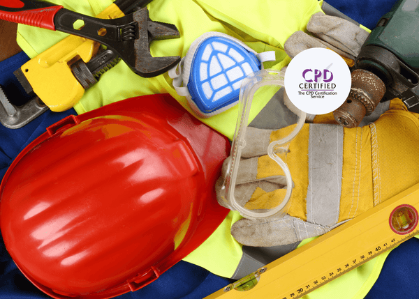 Construction PPE and tools, including gloves, goggles, a hard hat, and a mask, arranged on high-visibility clothing.