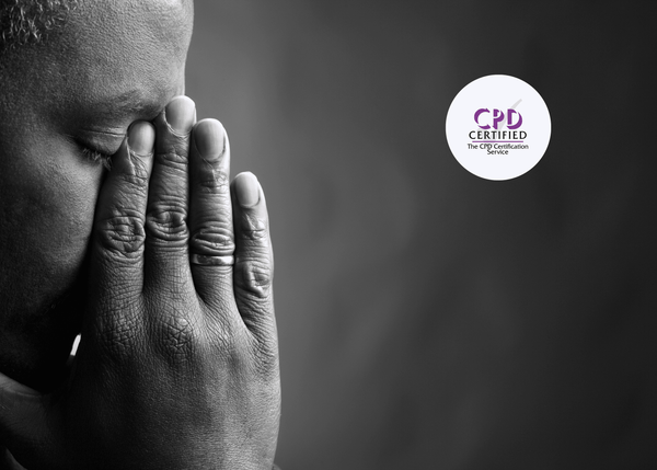 Close-up of a troubled man with his eyes closed, hands pressed together in front of his face.