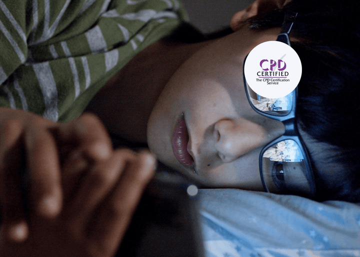 A child lying in bed at night, using a smartphone to browse social media, with the screen's glow reflected in their glasses.