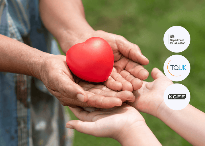 An elderly pair of hands passes a red heart-shaped object into the open palms of a child outdoors, symbolising care, support, and generational connection.