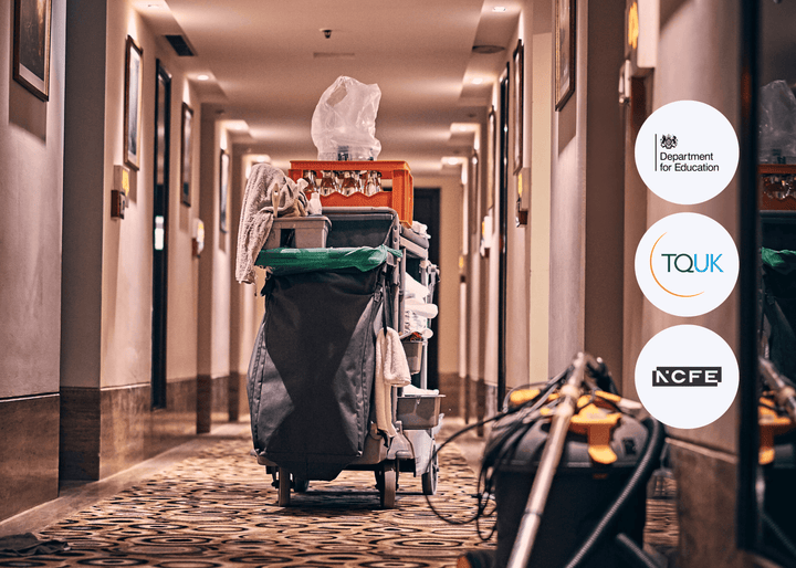 A cleaning trolley stocked with supplies is positioned in a hotel hallway with patterned carpet and wall lighting, ready for housekeeping duties.