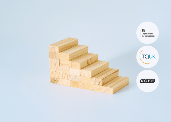 Side view of wooden blocks neatly stacked in a staircase formation on a flat, neutral surface.