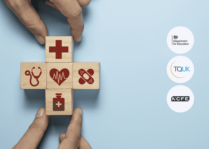 Hands arrange wooden blocks with red medical symbols into the shape of a cross on a light blue surface, symbolising healthcare and support services.