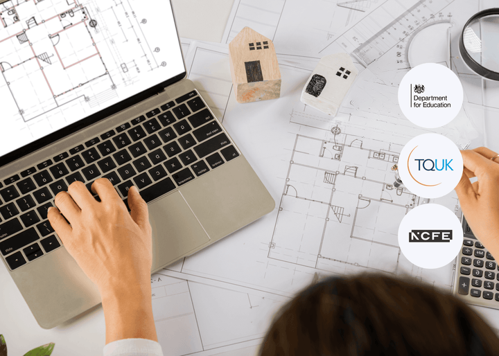 A person works on a laptop displaying architectural drawings, surrounded by floor plans, wooden house models, and tools, symbolising digital skills in construction.