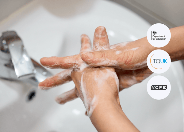 Close-up of hands being washed under running water, thoroughly scrubbed with soap and covered in lather to highlight proper hygiene practices.