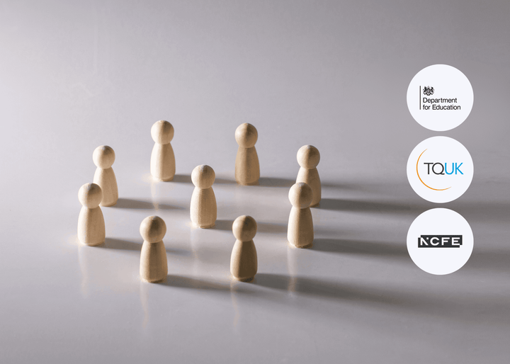 Nine plain wooden figurines arranged in a loose circle on a reflective surface, lit softly from one side, symbolising community, protection, and safeguarding.